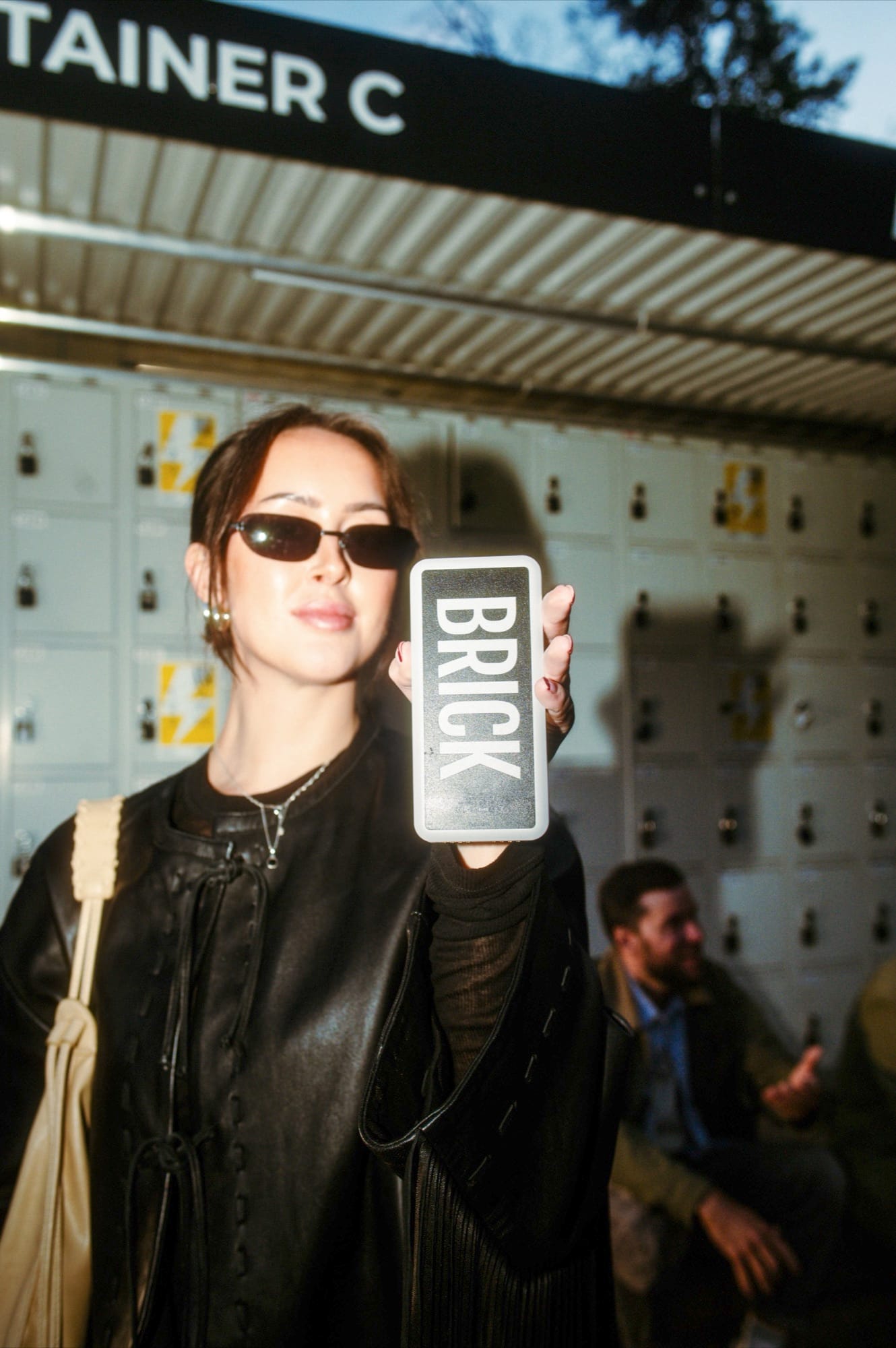 A woman in a city street holding up a Brick powerbank